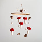 Handmade woodland nursery baby mobile with felt toadstools, acorns and wooden hanging frame