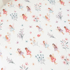 Fairy Garden organic cotton fitted cot sheet laid flat showing whimsical fairies, flowers and soft pastel garden illustrations