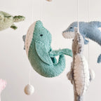 close up felt whale on baby mobile