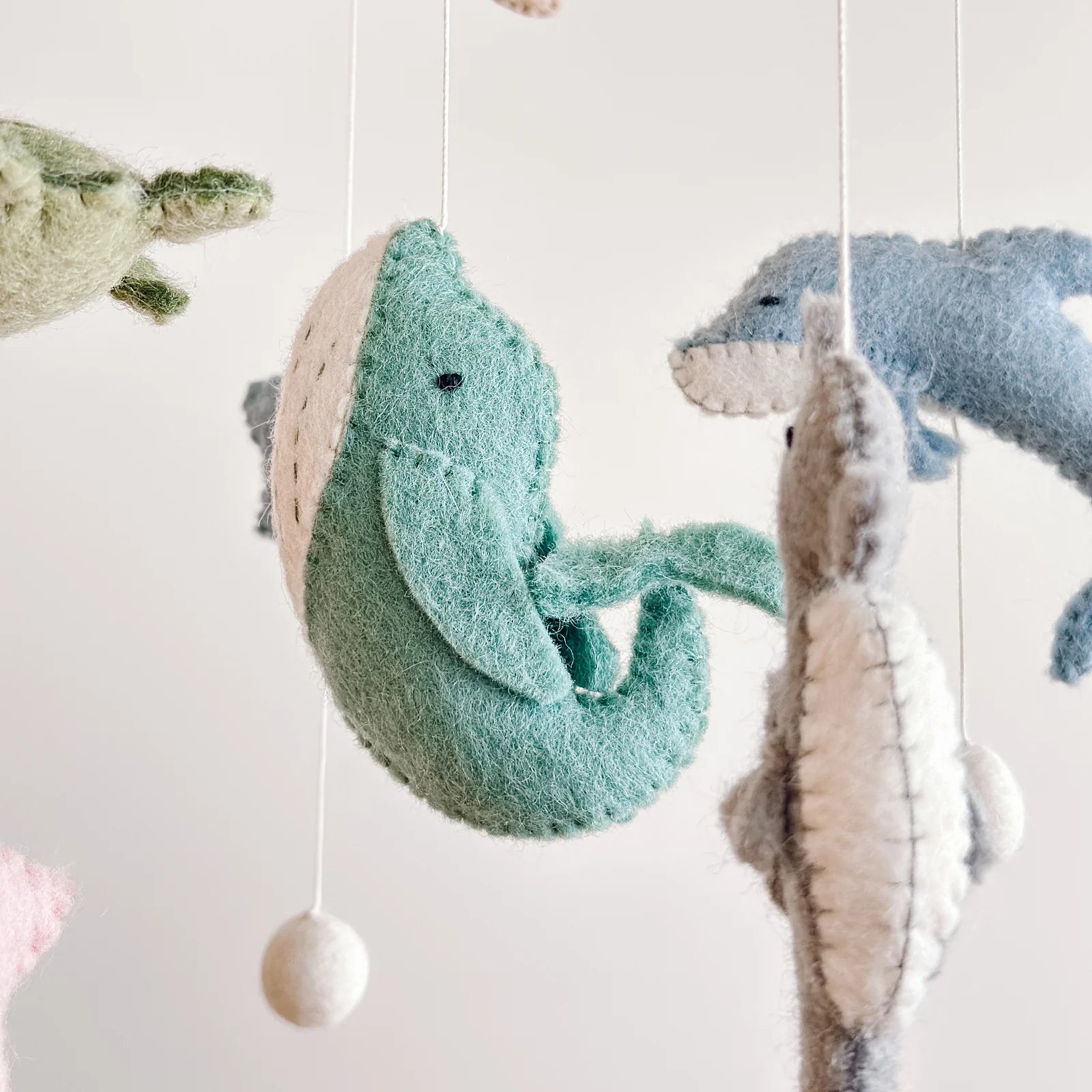 close up felt whale on baby mobile