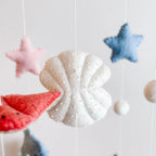 Decorative mobile with starfish and shell shapes on a light background