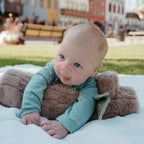 baby holding soft tummy time log sensory bead filled pillow
