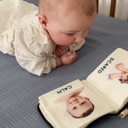 Baby looking at a book with images of itself labeled 'Calm' and 'Scared'.