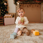 Baby playing with Little Lamb Kind soft stacking block set in neutral pastel colours