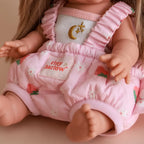 close up of photoshoot of baby dolls carrier made by tiny harlow with baby inside. good for pretend play, the print is strawberry picnic