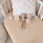 Babyccino fitted cot sheet by Snuggle Hunny on a baby cot in a warm beige neutral nursery setting