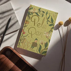 photoshoot Peter Pan limited collector’s edition hardcover by J.M. Barrie with green illustrated cover, gold foil title, cloth-bound finish and decorative sprayed edges, stacked on books.