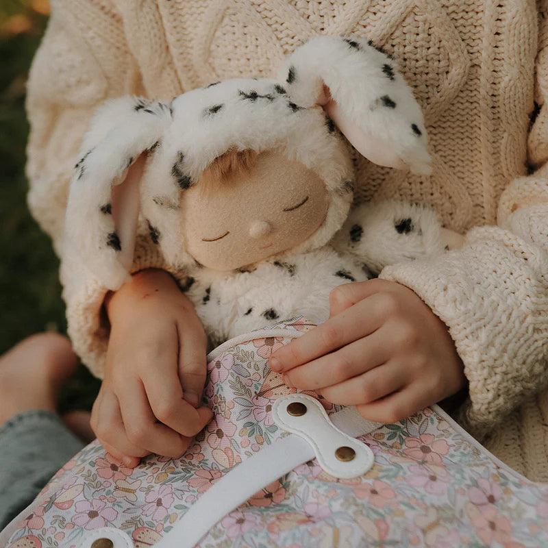 Child holding Domino Dog Cozy Dinkum doll Olli Ella