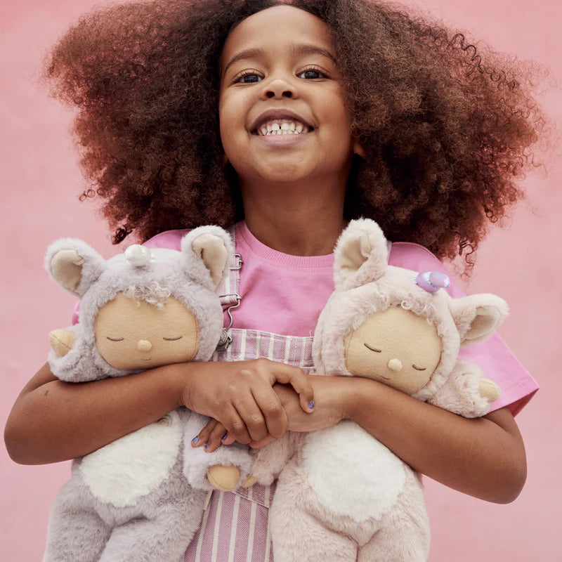 Child holding Sugarpie unicorn Cozy Dinkum doll Olli Ella
