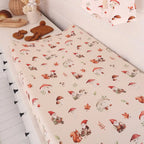Gnomes organic change pad cover stretched over a baby change mat showing soft breathable cotton fabric and woodland print