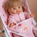 close up photo of baby doll kids stroller for pretend play with mini coletto doll inside. made by brand tiny harlow. print pictured is strawberry picnic