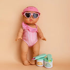 a summer themed  mini coletto doll in swimmer, hat and sunnies showcasing the tiny tummies pretend play doll food jars that disappear like real food. brand is tiny harlow and tiny tummies food jar flavour is the italian gelato pack which is lemon sorbet and cherry gelato