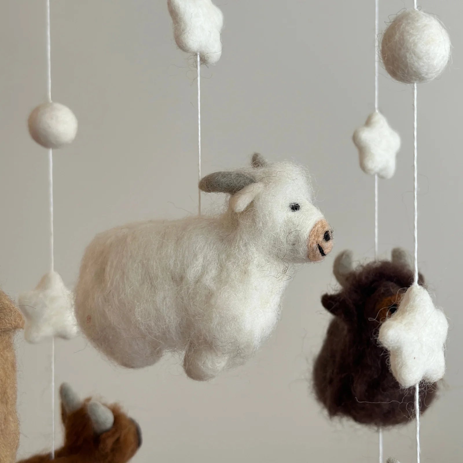 close up of white highland cow on nursery cot mobile