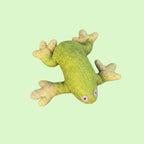 A green felted wool frog toy with textured yellow-green webbed feet and small purple eyes, isolated on a white background.
