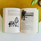 inside look at The Wizard of Oz collector’s edition hardback book with green illustrated cover and gold foil lettering by L. Frank Baum