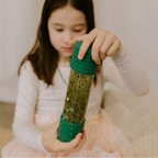 Jellystone Designs DIY Calm Down Bottle in Dinosaur with green black silver and iridescent sensory elements