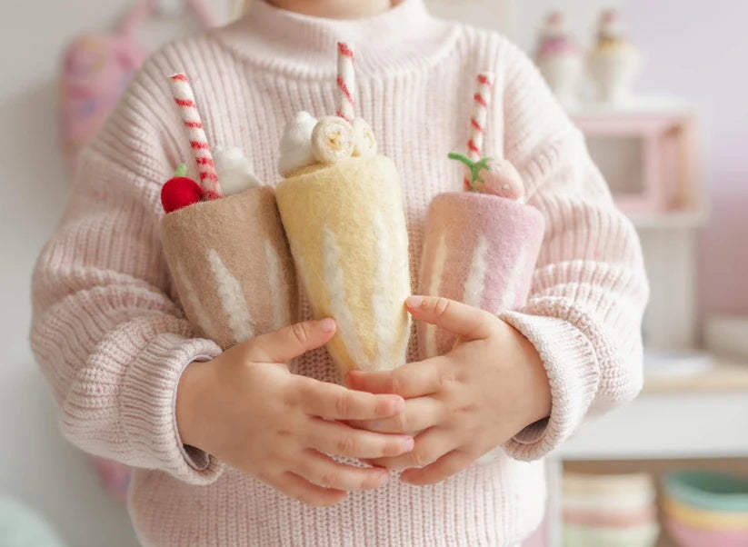 child holding during play felt strawberry, chocolate and banana milkshake toy handmade wool pretend play drink diner Juni Moon