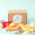 Cardboard box with 'Felt Fish & Chips' label, felt fish, chips, and lemon on newspaper form juni moon
