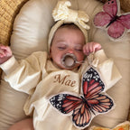 baby holding soft butterfly toy with crinkle and rattle features