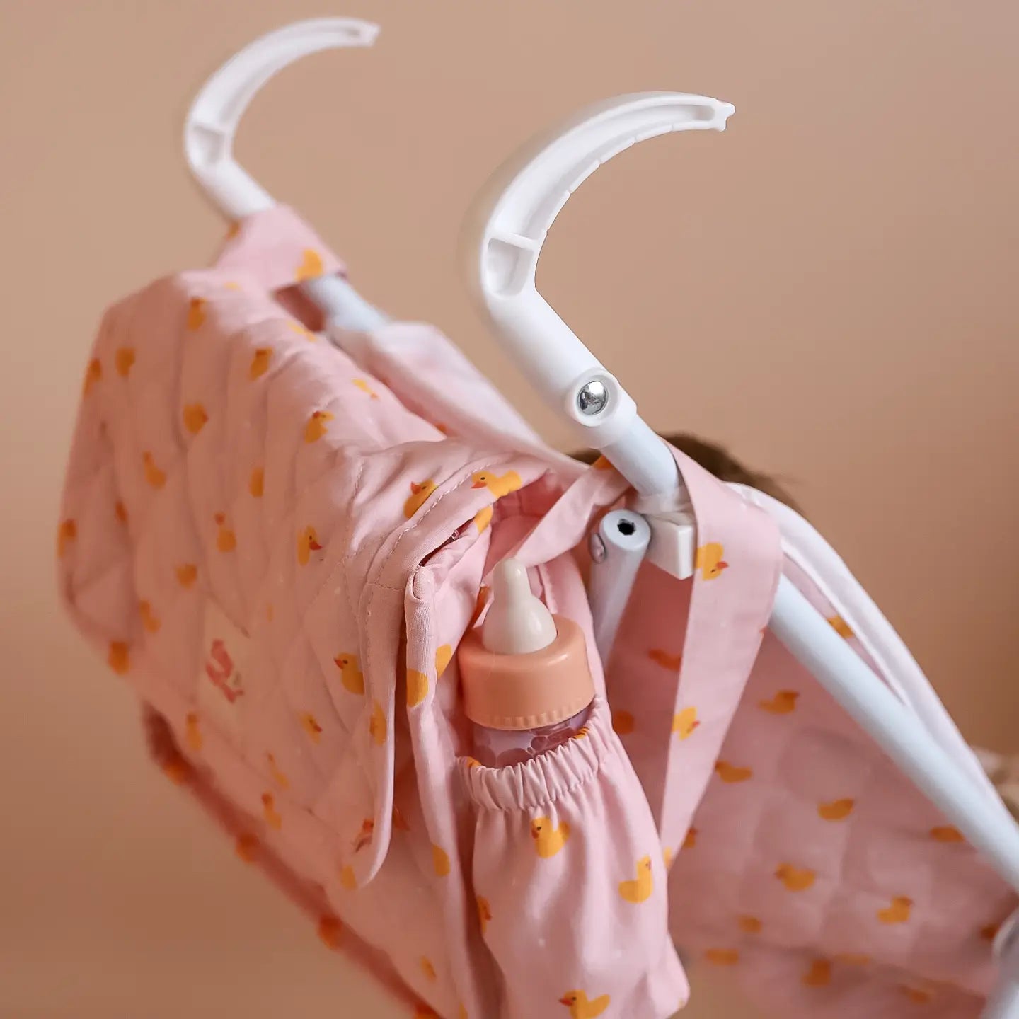 showing how the tiny harlow nurturer kit can fit on the back of baby doll kids stroller for pretend play with kids dolls made by brand tiny harlow. print pictured is pink ducky