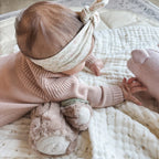 baby using tummy time log pillow for support during tummy time