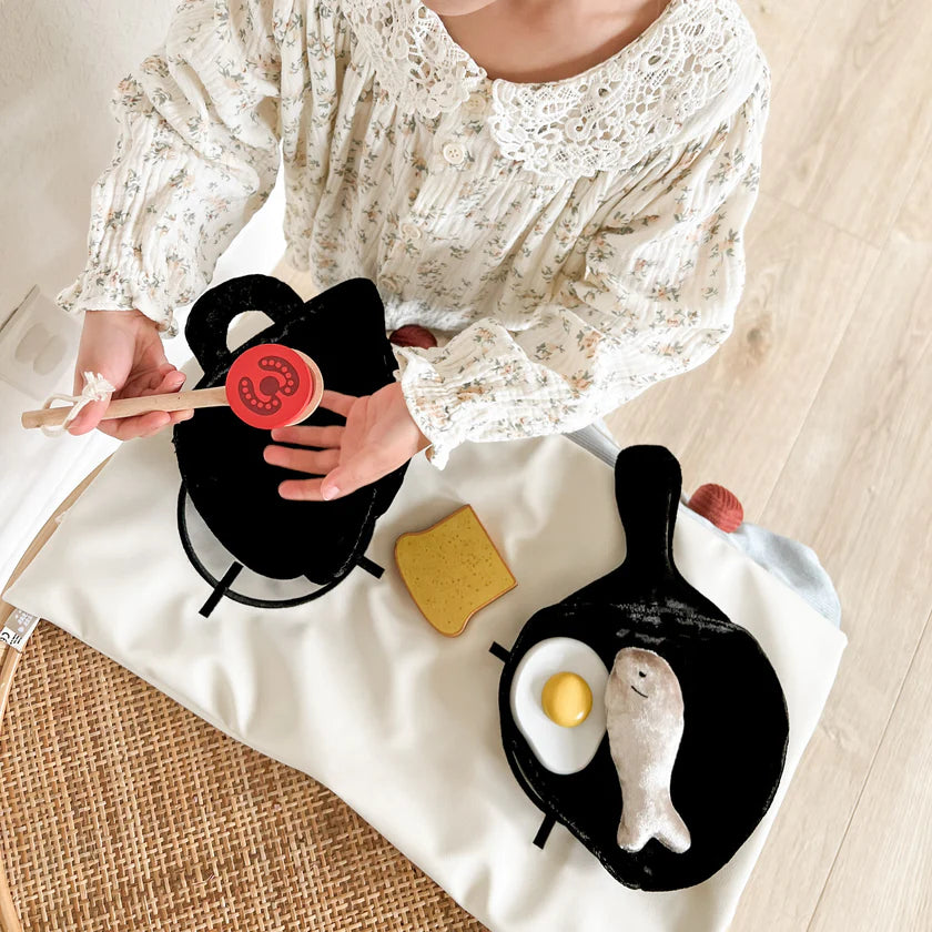 Child playing with Little Lamb Kind Little Nomad Kitchen set