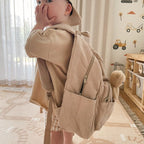 side view of child wearing Corduroy kids backpack with front pocket, laptop sleeve, health label, name label, options to personalise a name with embroidery, spacious. perfect for school or travel. this colour is latte